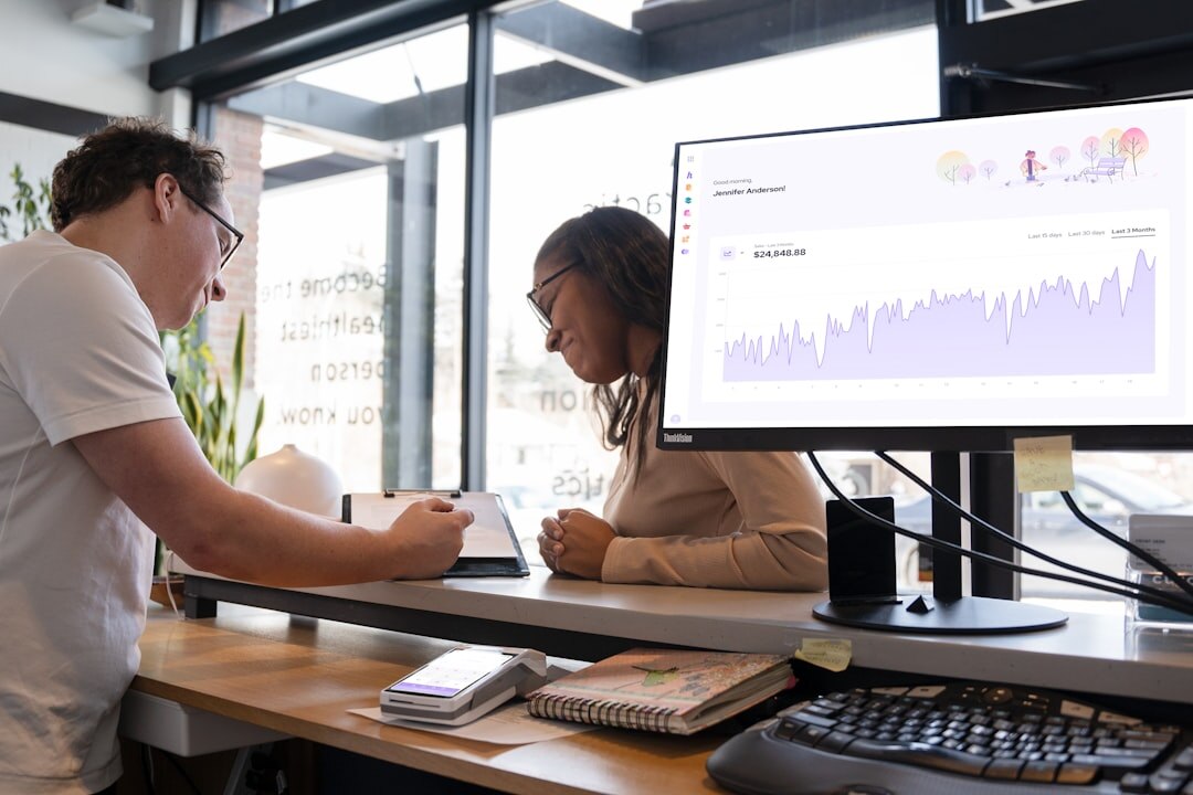 Two colleagues reviewing video feeds on a monitor