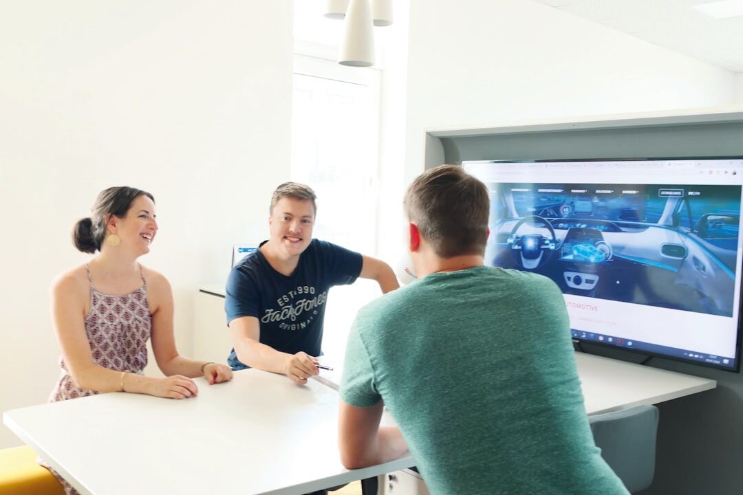 Group of colleagues discussing in front of a screen