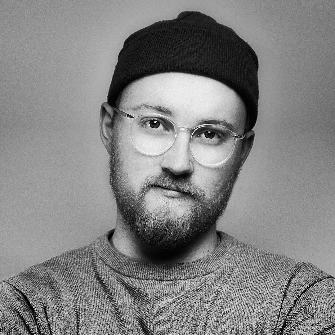 Studio portrait of a smiling European man with glasses